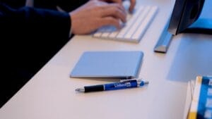 man working on desk with LinkedIn pen
